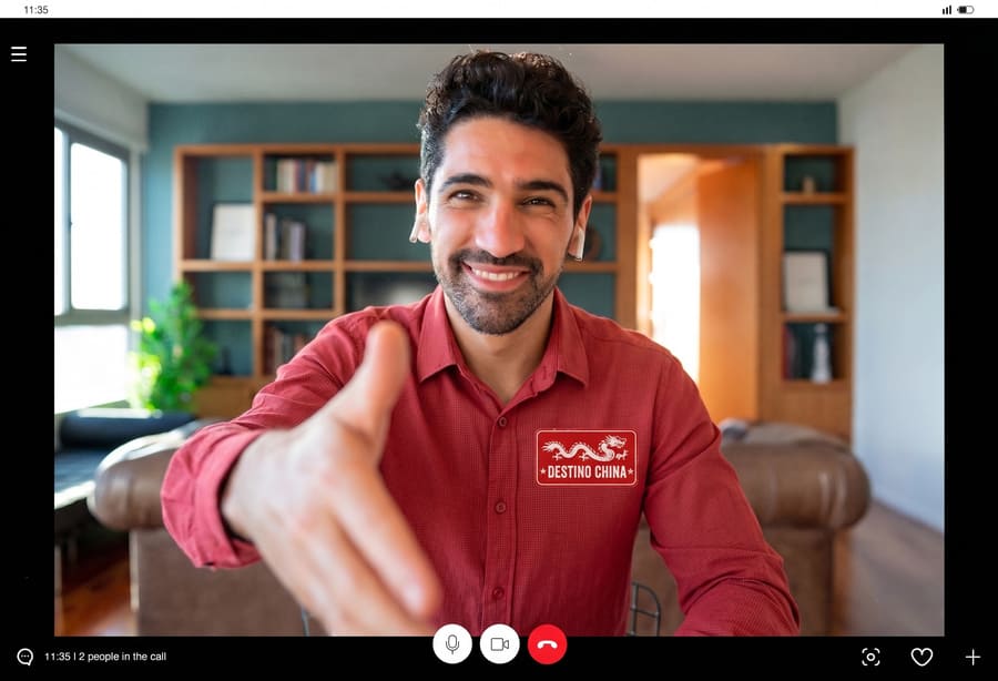Asesor de la agencia Destino China saludando durante una videollamada de asesoría personalizada para la planeación y diseño de viajes a medida a China.