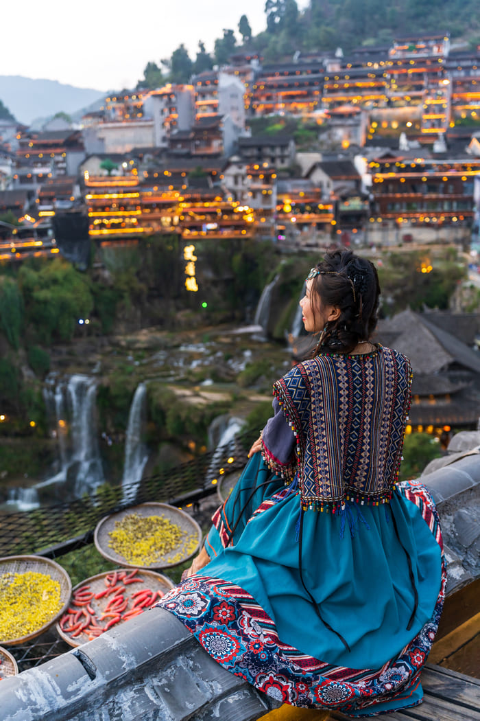 Chica admirando la ciudad de lijiang por el amanecer